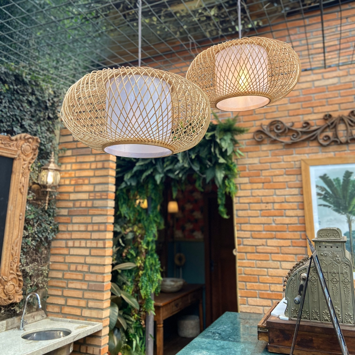 Lustre de Palha em ambiente com parede de tijolos